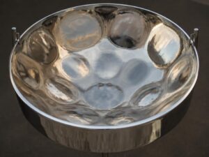 A chrome steelpan drum on its stand, showing the hammered note areas of its playing surface in Trinidad and Tobago