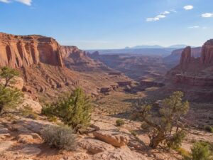Red rock desert canyon country with layered sandstone cliffs, sagebrush and juniper in the United States